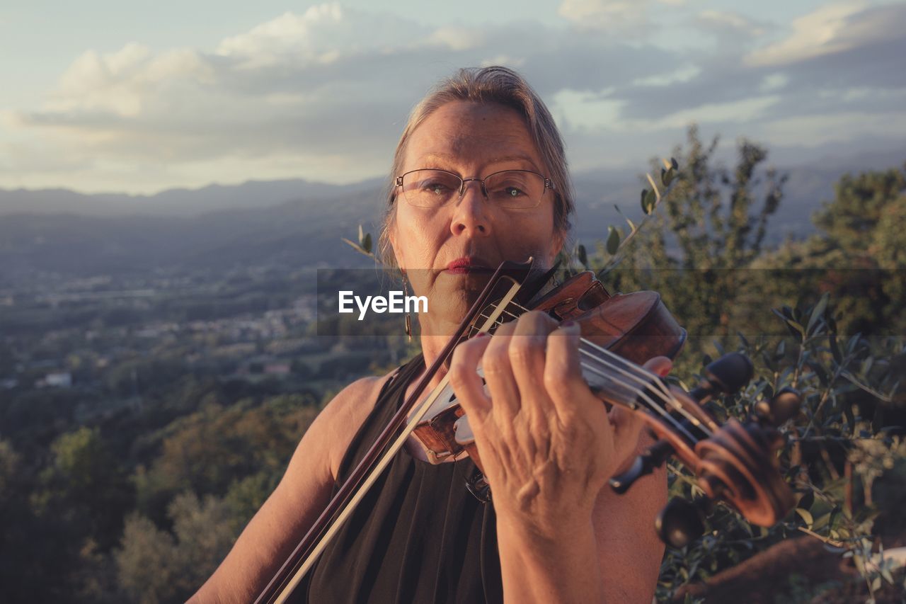 Portrait of mature woman playing violin