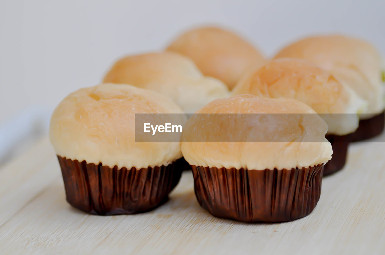 CLOSE-UP OF CUPCAKES ON TABLE AGAINST WHITE BACKGROUND