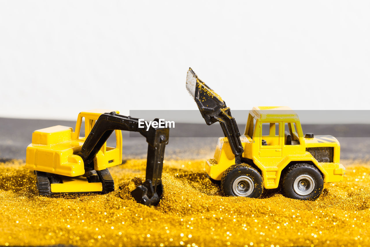 Close-up of toy construction machinery in sand
