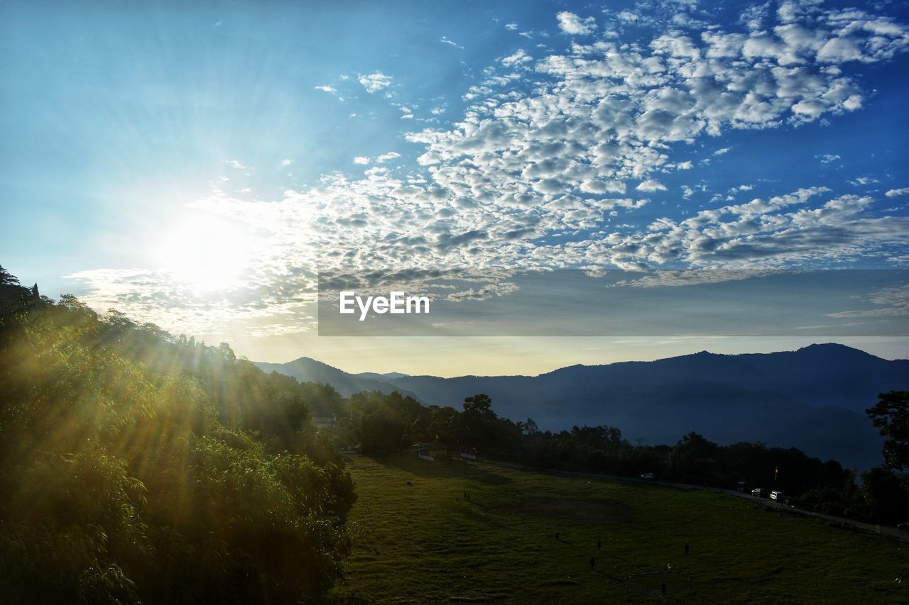 nature, sky, environment, landscape, sunlight, mountain, scenics - nature, beauty in nature, morning, cloud, sun, land, sunbeam, plant, tranquility, mountain range, tree, horizon, dawn, tranquil scene, rural scene, forest, blue, travel, no people, summer, sunrise, lens flare, outdoors, grass, non-urban scene, idyllic, travel destinations, field, fog, tourism, back lit, valley, mountain peak, twilight, pinaceae, light, vacation, holiday