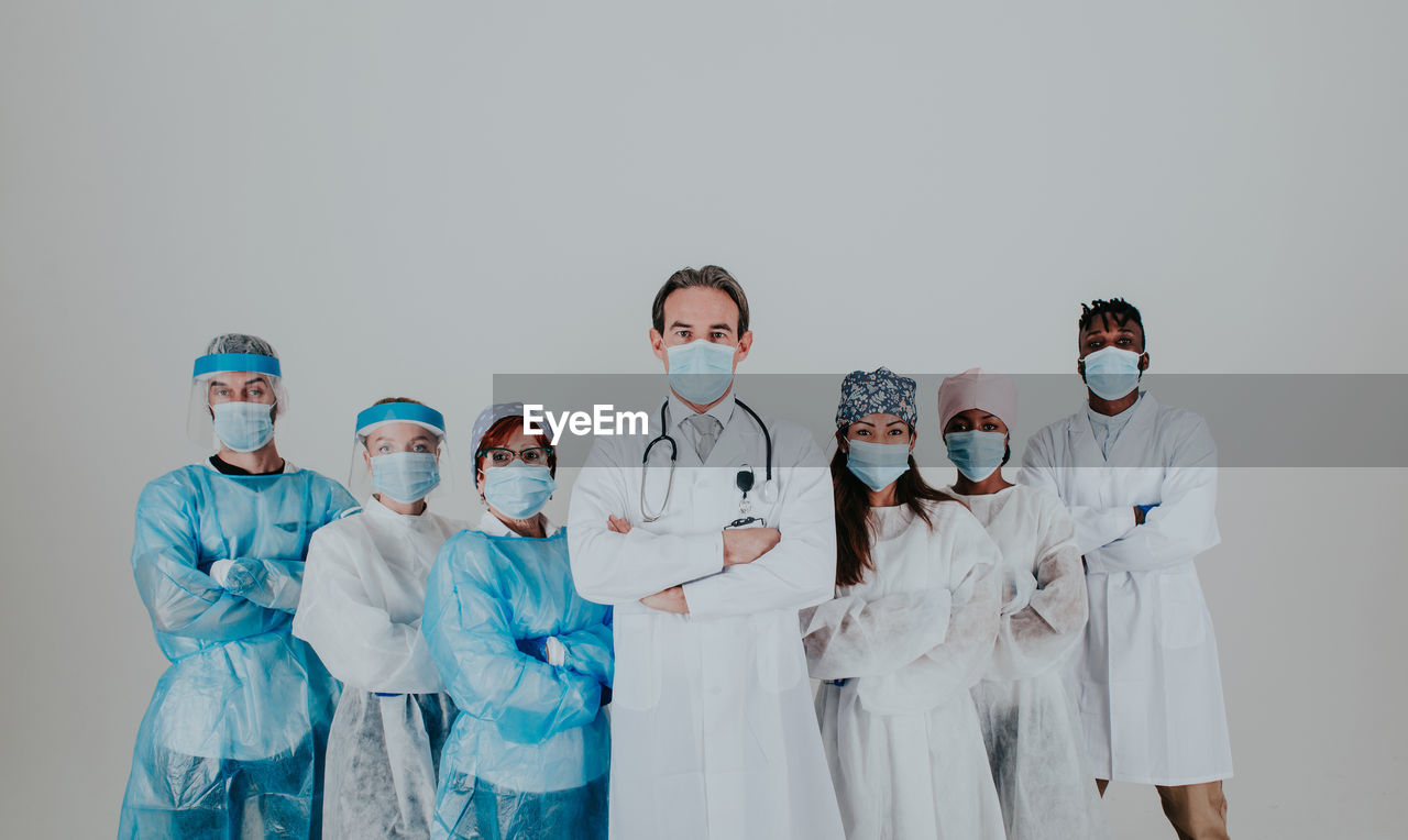 Doctors wearing mask standing against white background