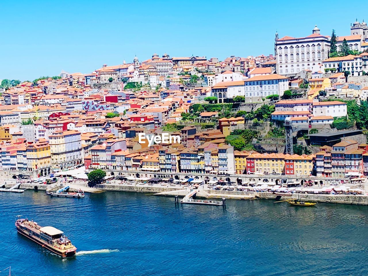 AERIAL VIEW OF TOWNSCAPE BY RIVER AGAINST SKY