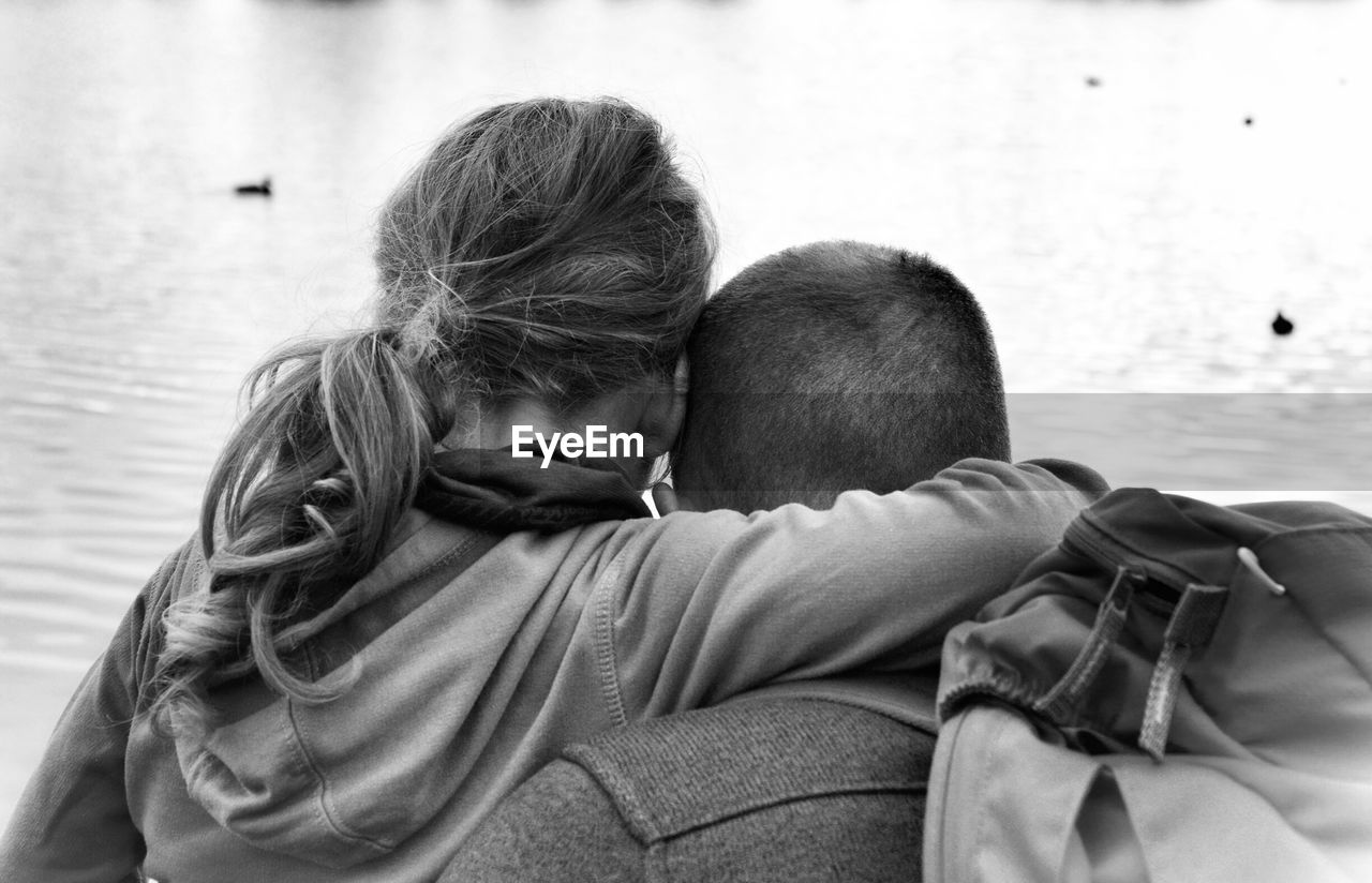 Rear view of couple in front of lake