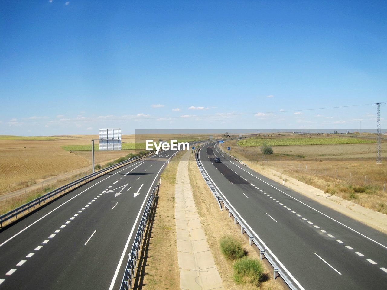 Roads amidst field against sky