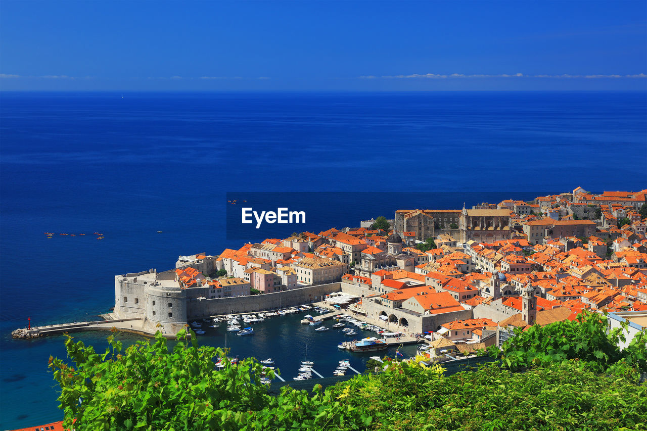 High angle view of sea and cityscape against sky