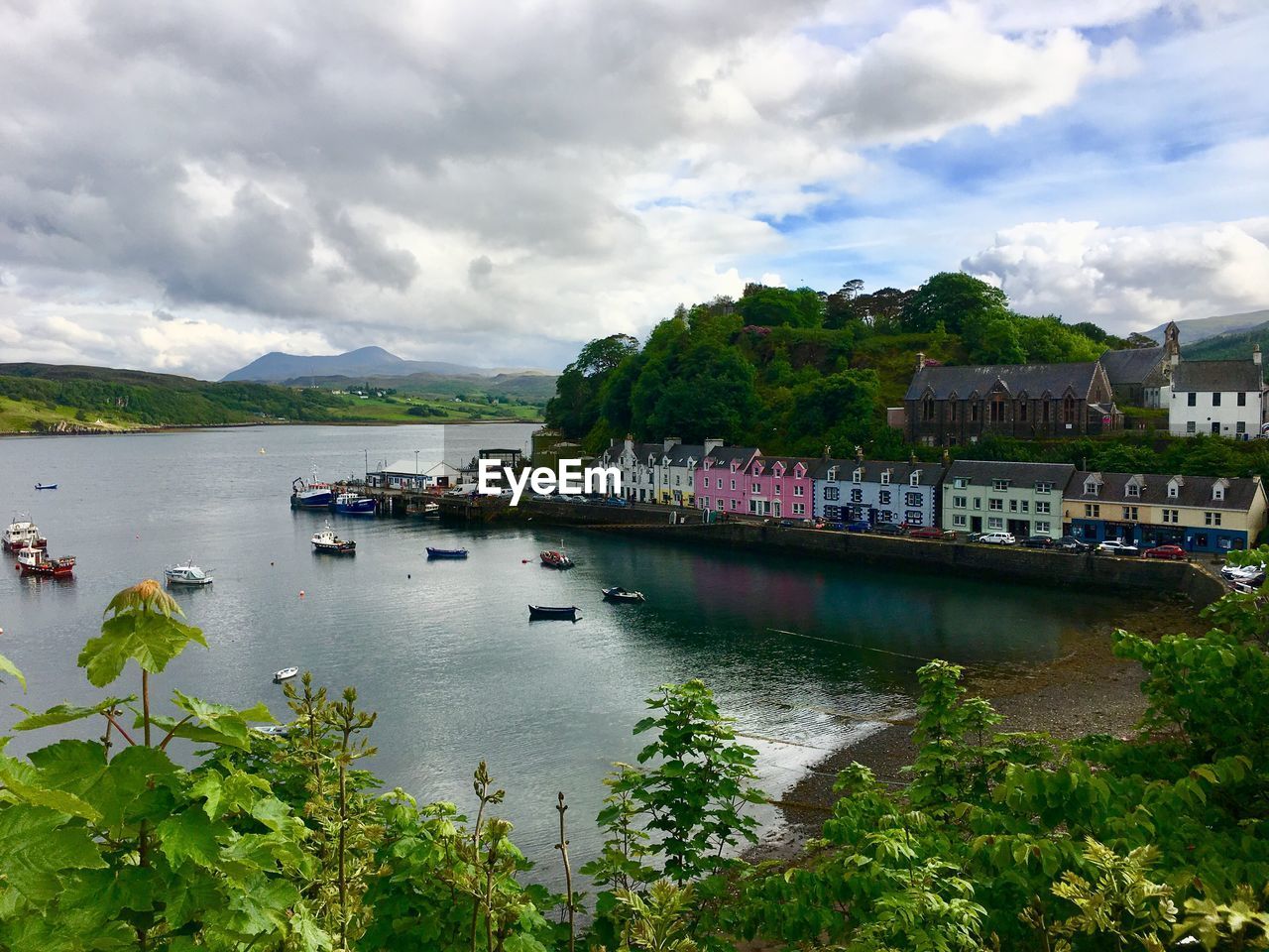 Scenic view of river by buildings against sky