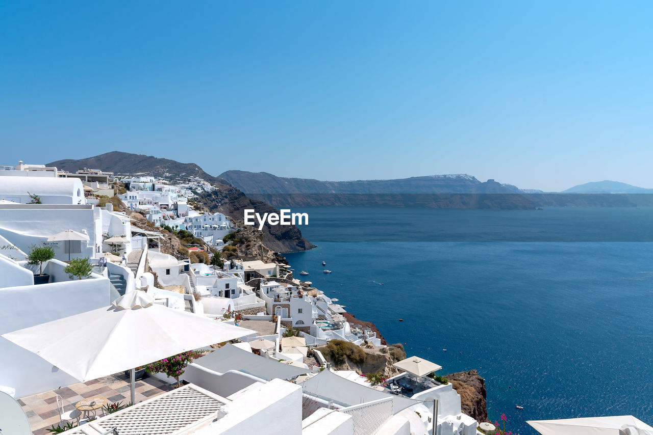 HIGH ANGLE VIEW OF BUILDINGS BY SEA AGAINST SKY