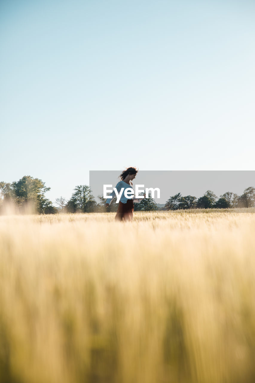 MAN ON FIELD AGAINST CLEAR SKY