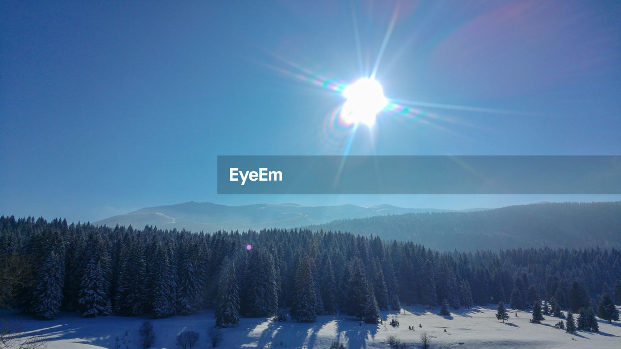 Scenic view of snowcapped mountains against blue sky