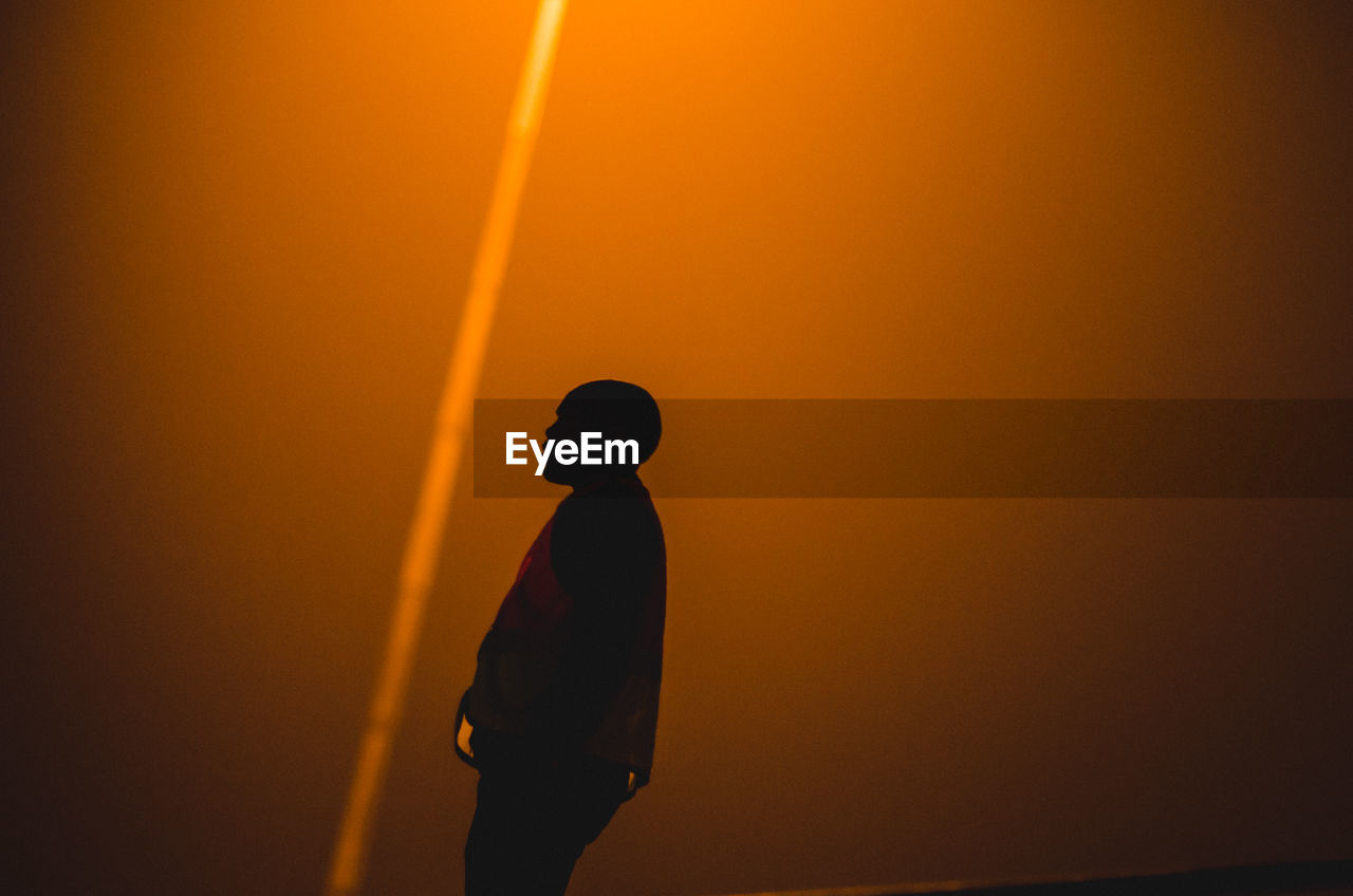 Silhouette man standing against sky during sunset