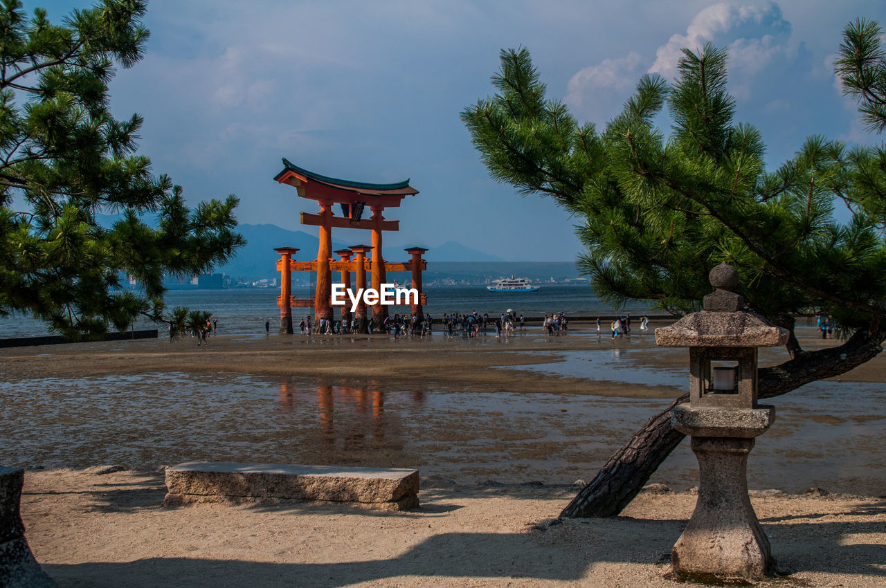 Shrine by lake against sky
