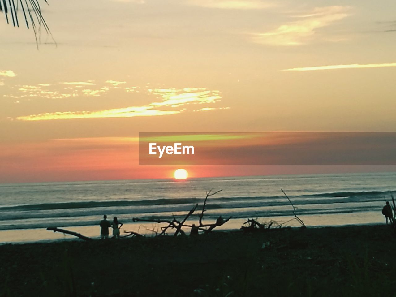 SCENIC VIEW OF BEACH AGAINST SKY AT SUNSET