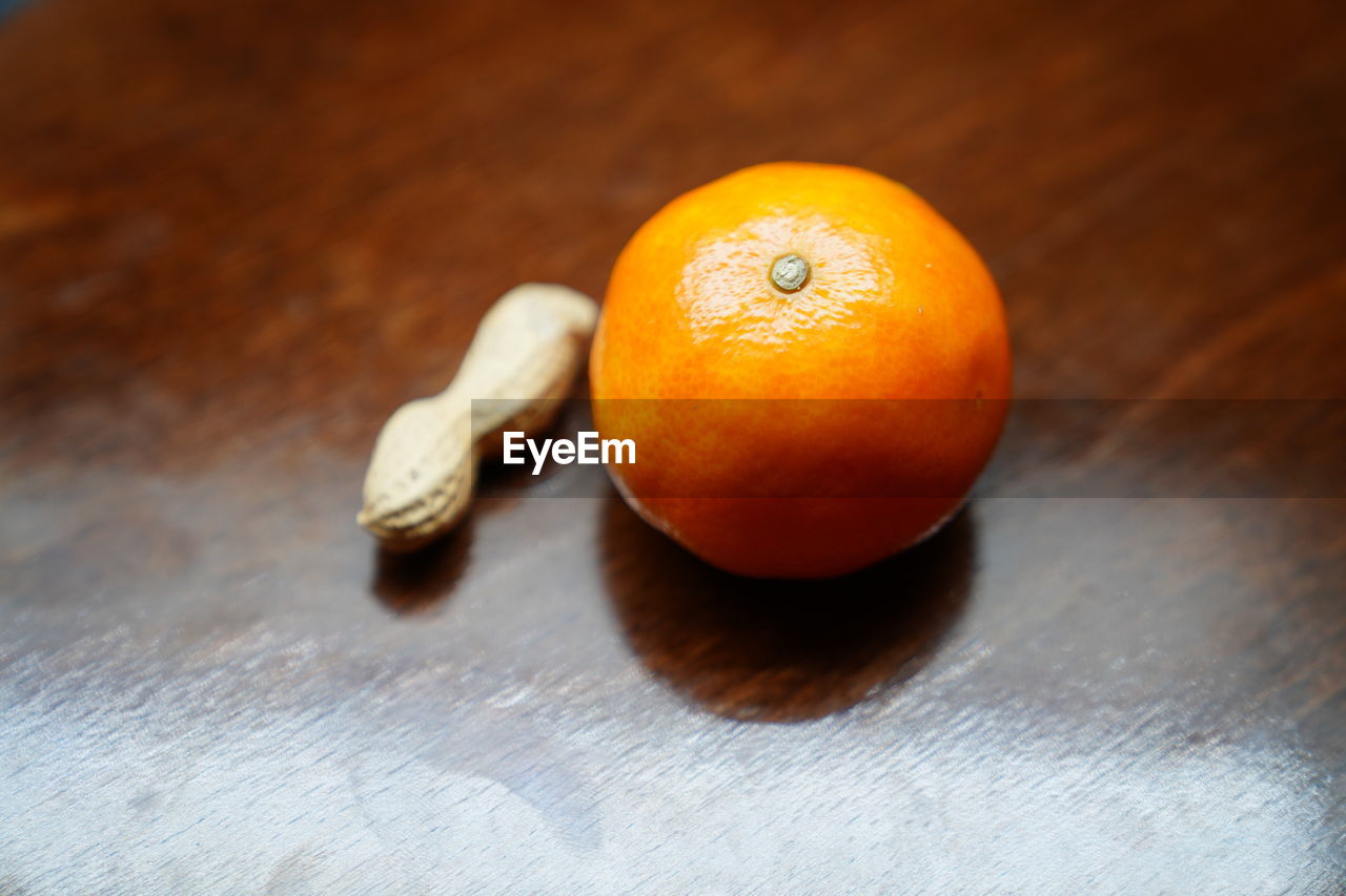 HIGH ANGLE VIEW OF ORANGE IN CONTAINER ON TABLE