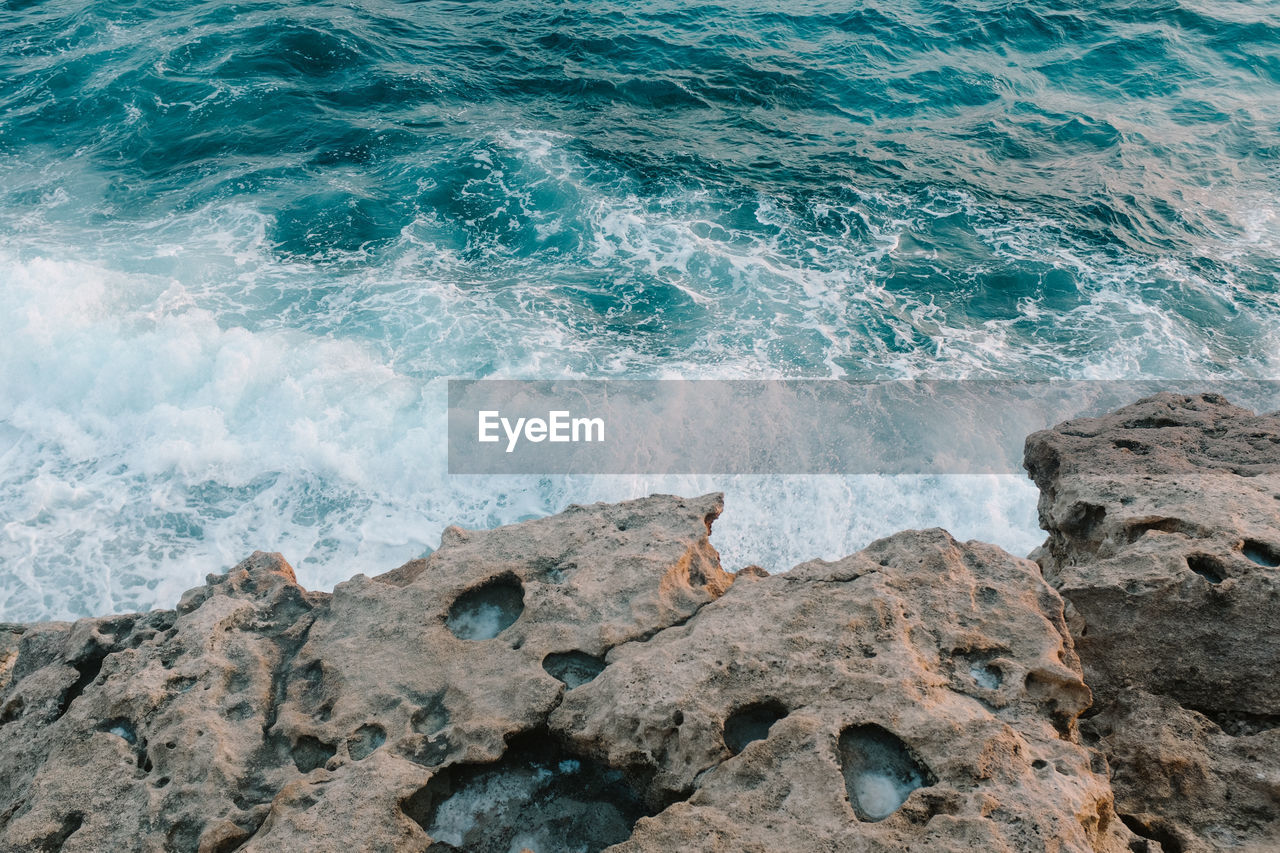 Blue sea waves on a rocky shore in cyprus