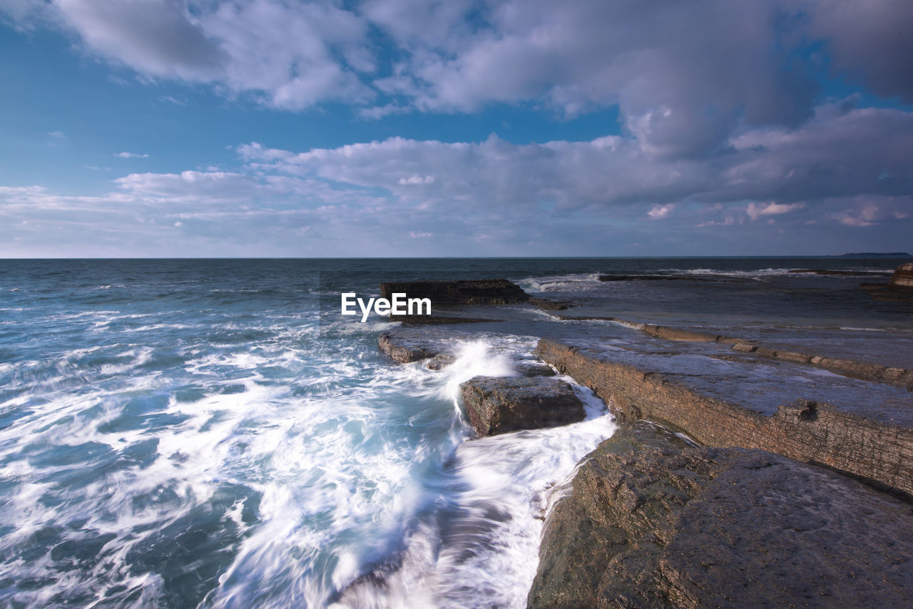 Scenic view of sea against cloudy sky