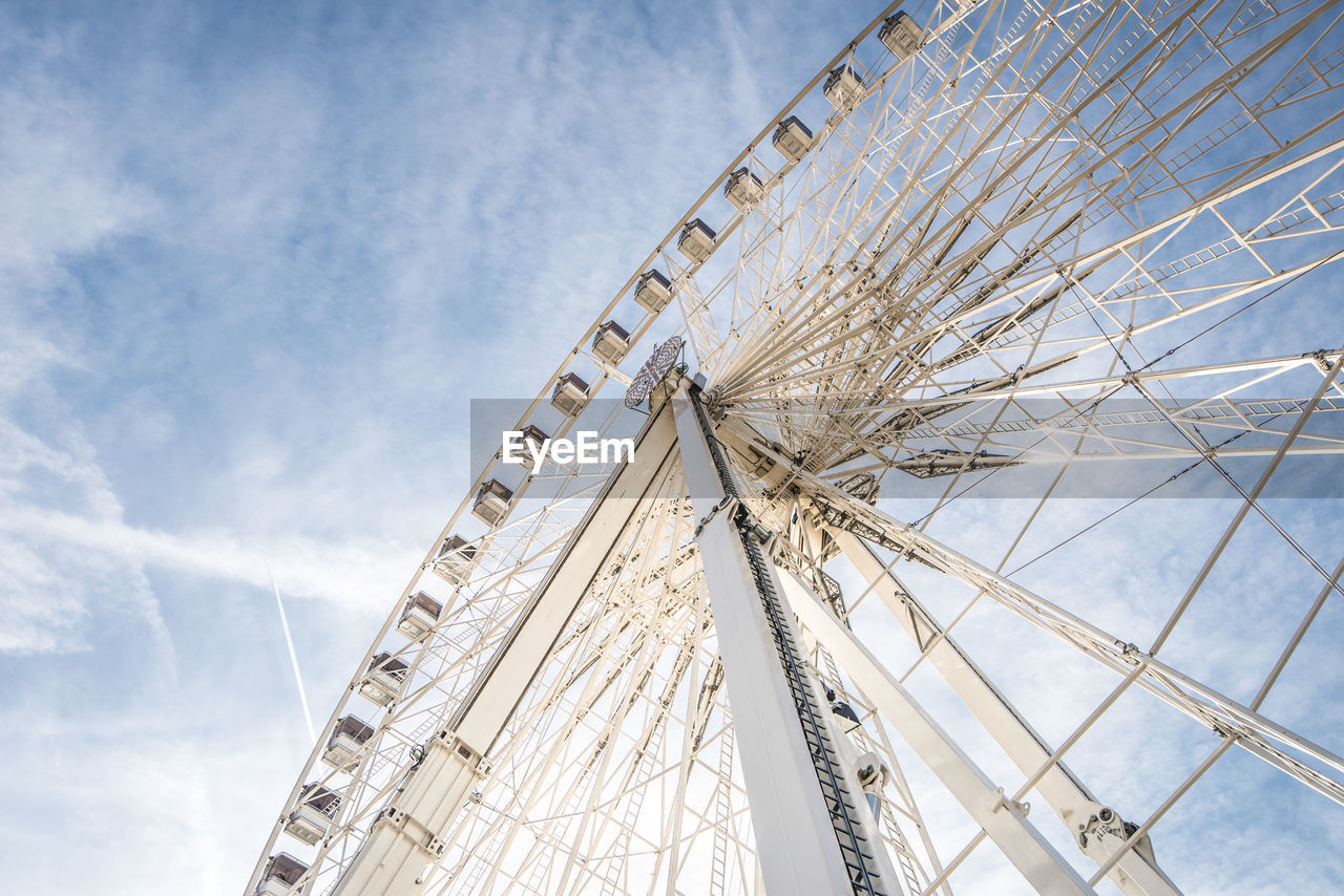 Low angle view of ferris wheel against blue sky