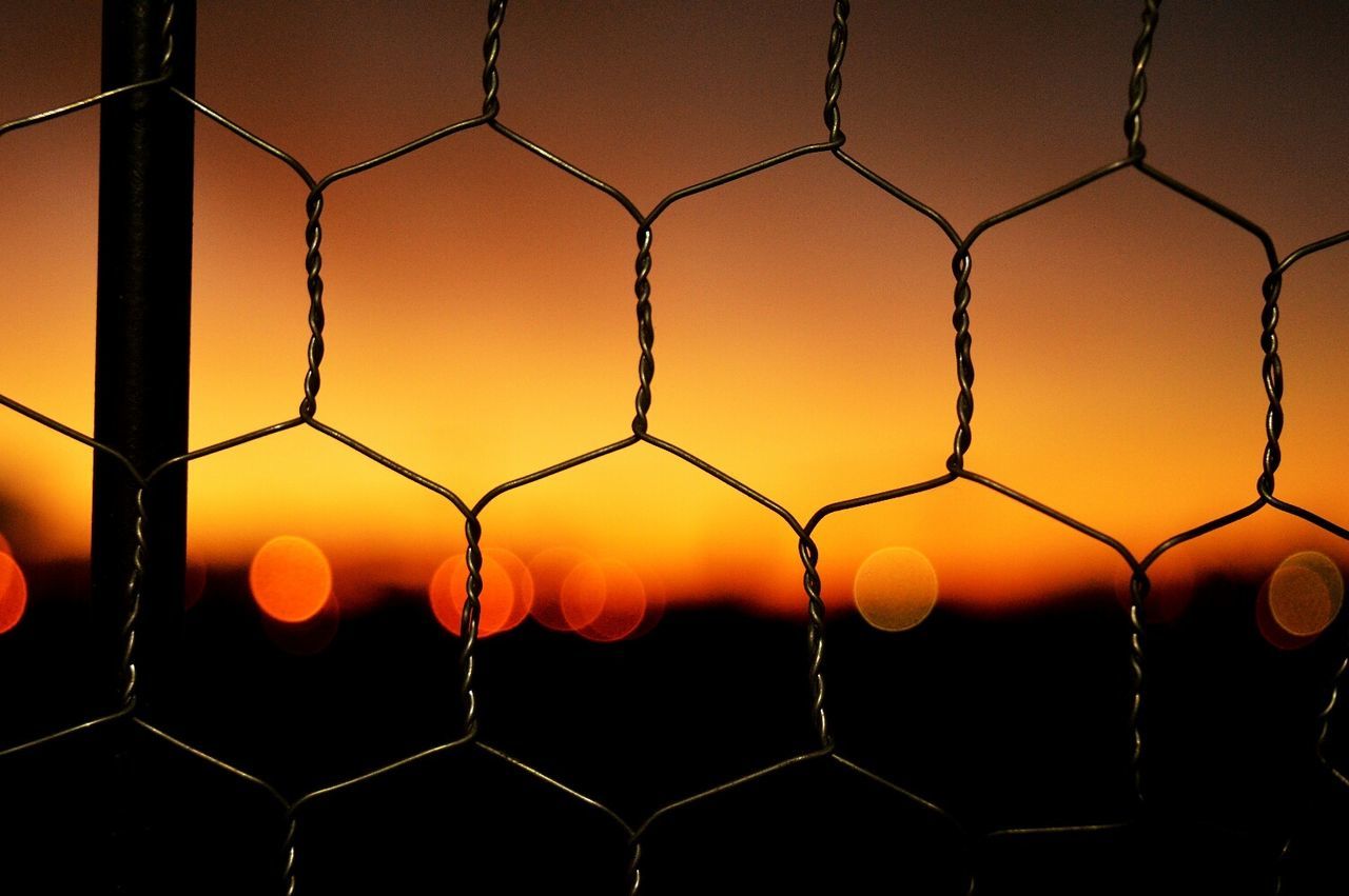 Full frame shot of fence against sky during sunset