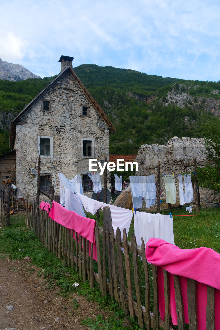 HOUSES ON FIELD AGAINST SKY