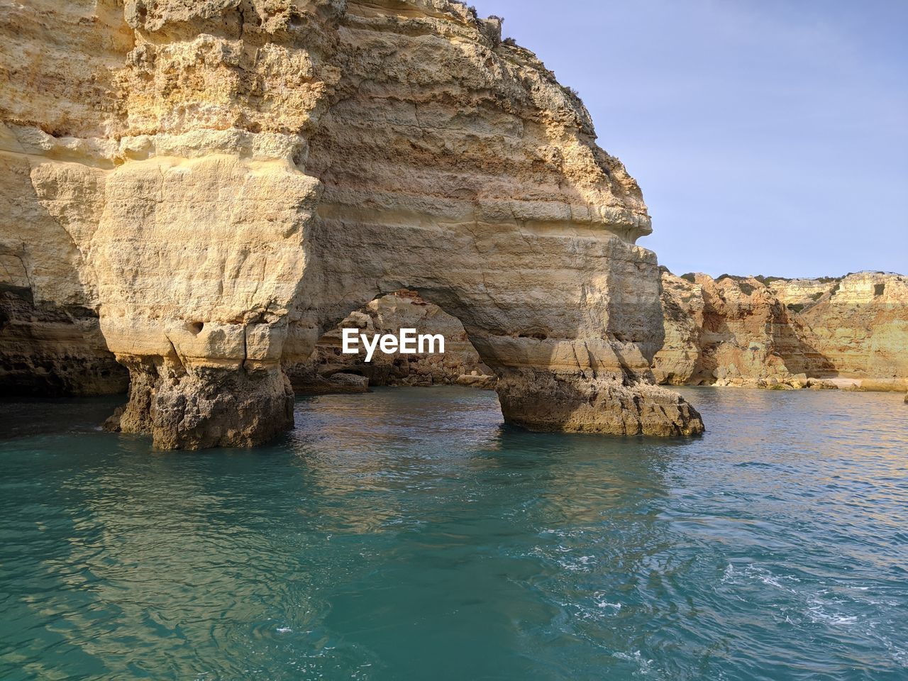 Rock formation in sea against sky