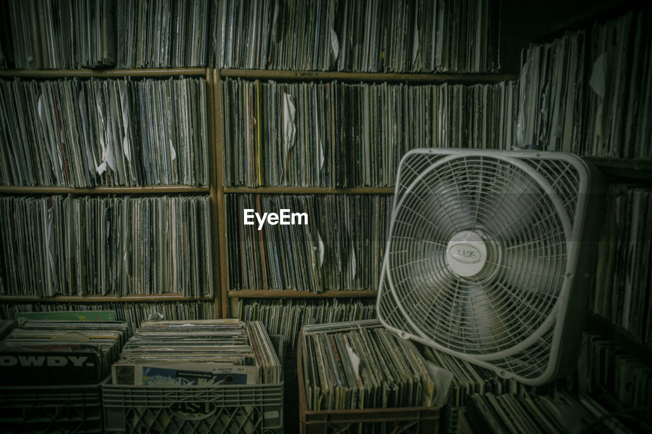 Electric fan on books in basement