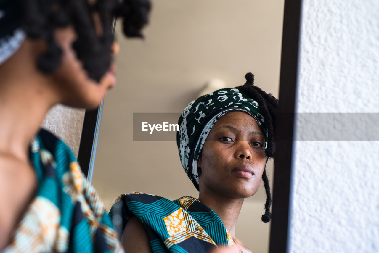 Woman reflecting on mirror at home