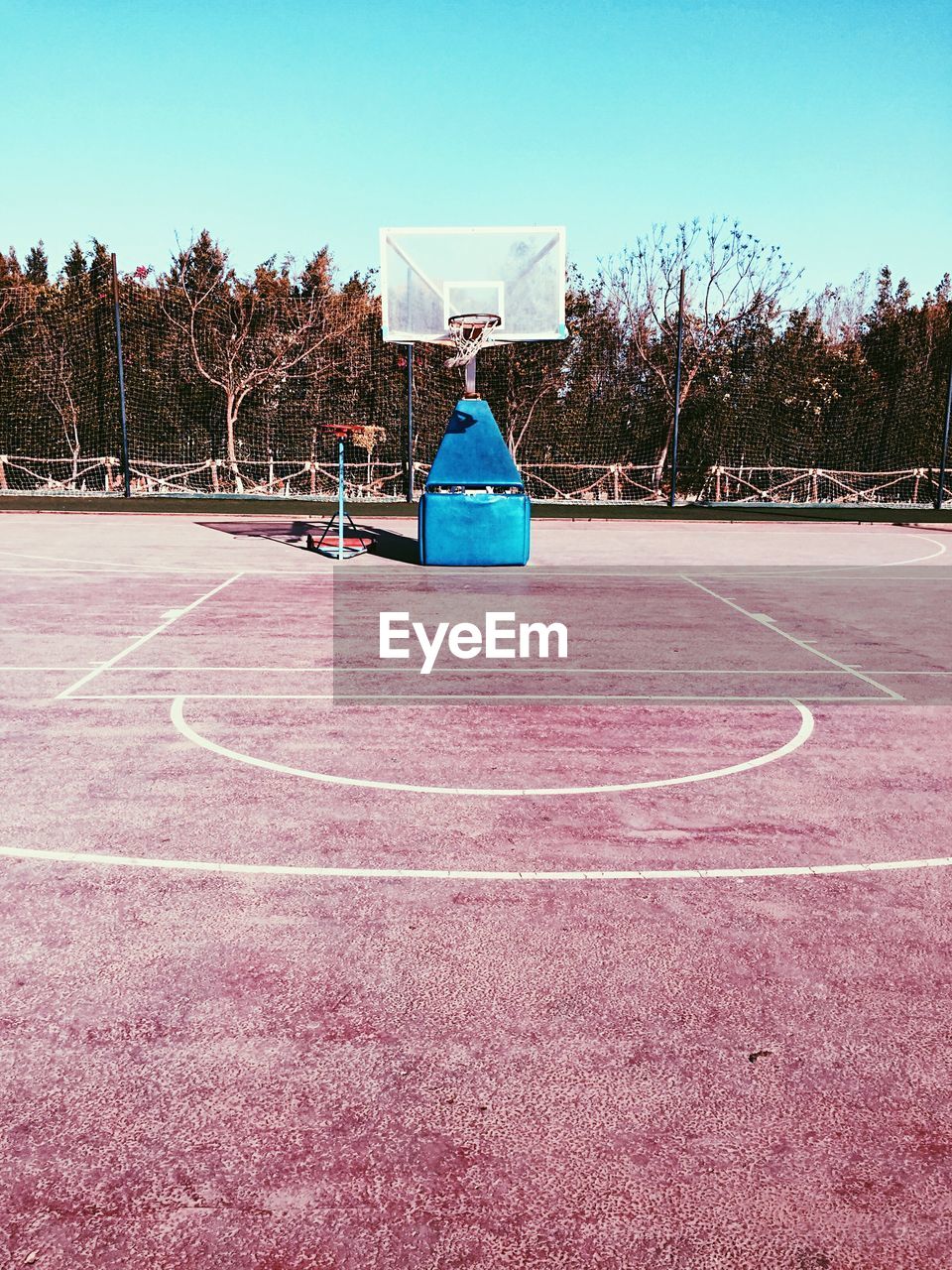 Basketball court against blue sky during sunny day