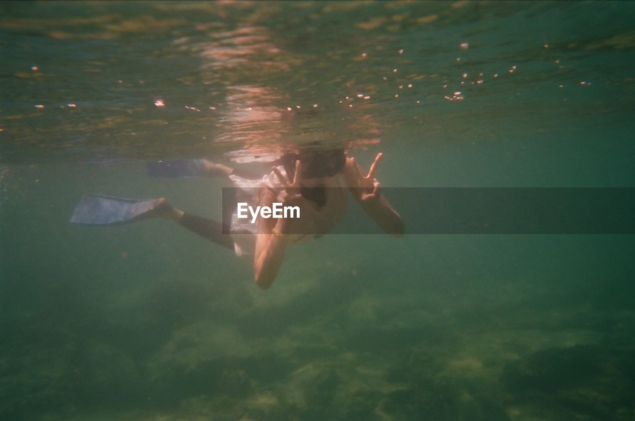 Rear view of woman swimming in sea