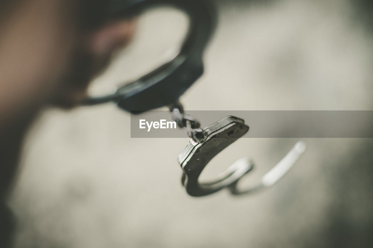 CLOSE-UP OF HUMAN HAND HOLDING METAL