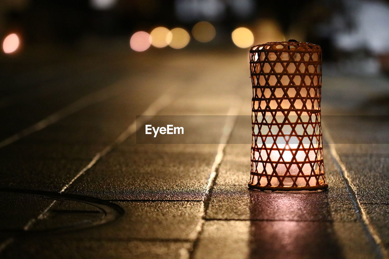 Illuminated lamp on footpath at night