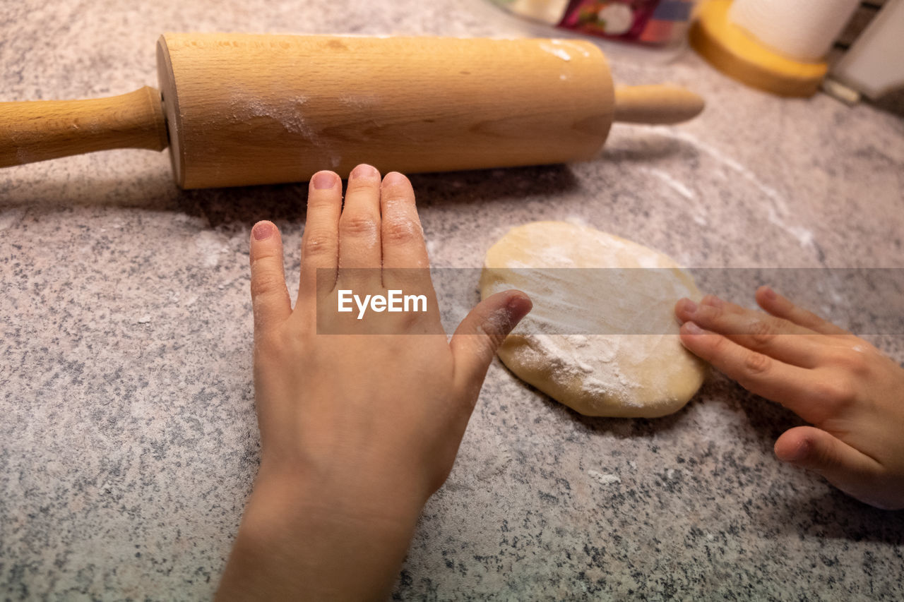 CROPPED IMAGE OF PERSON PREPARING FOOD IN KITCHEN AT HOME