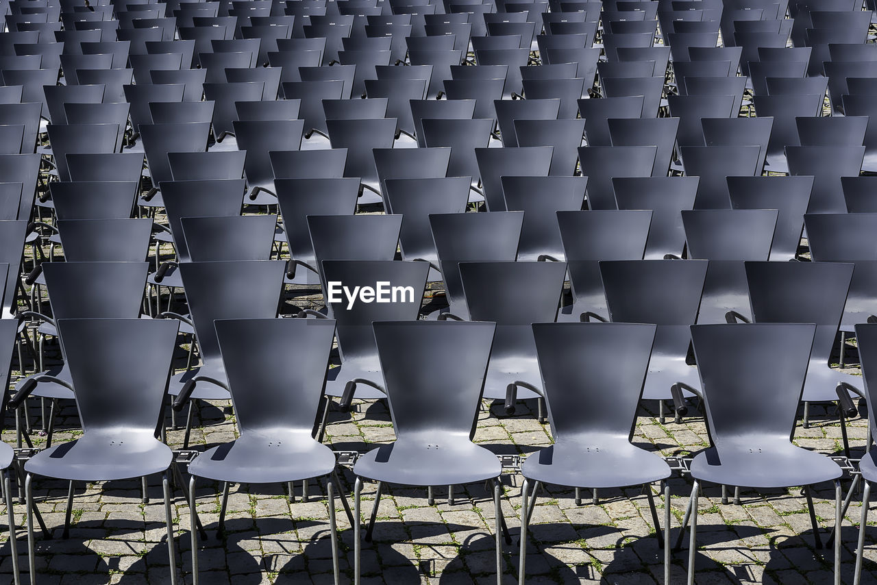 FULL FRAME SHOT OF EMPTY CHAIRS AND TABLE IN ROW