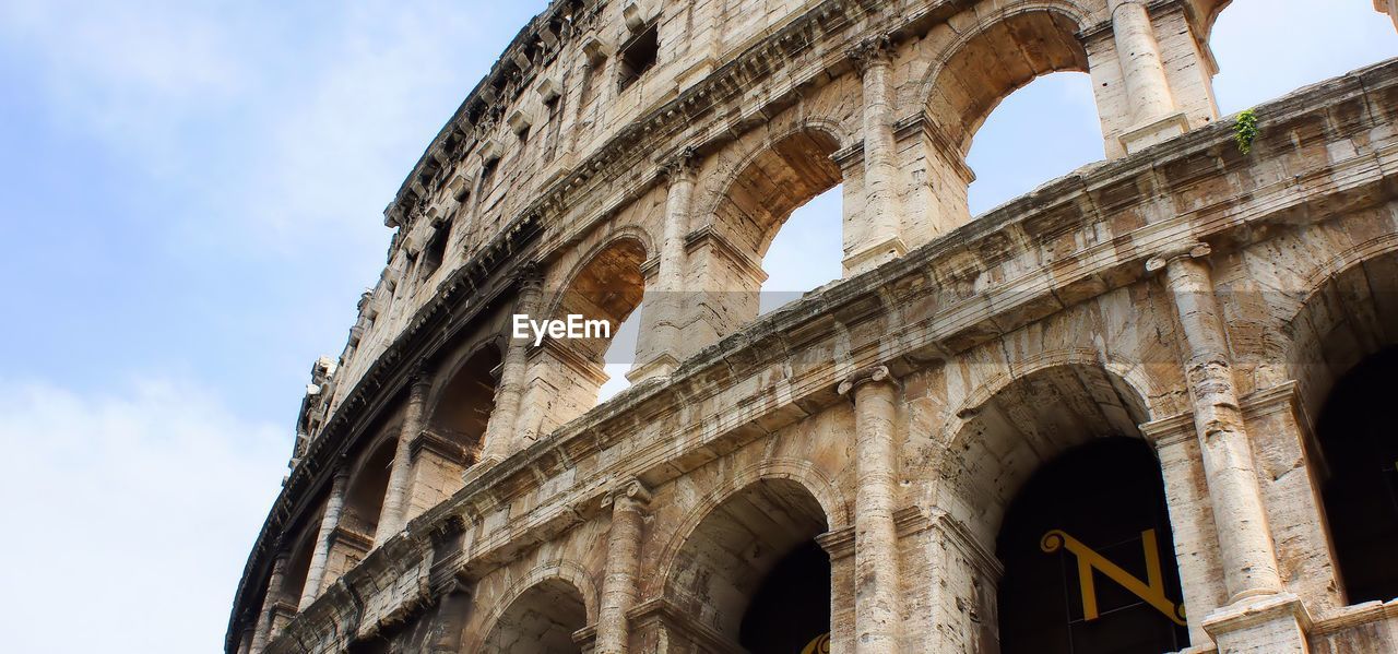 Low angle view of coliseum against sky