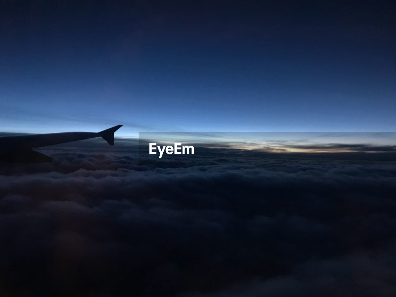 Airplane flying over cloudscape against sky