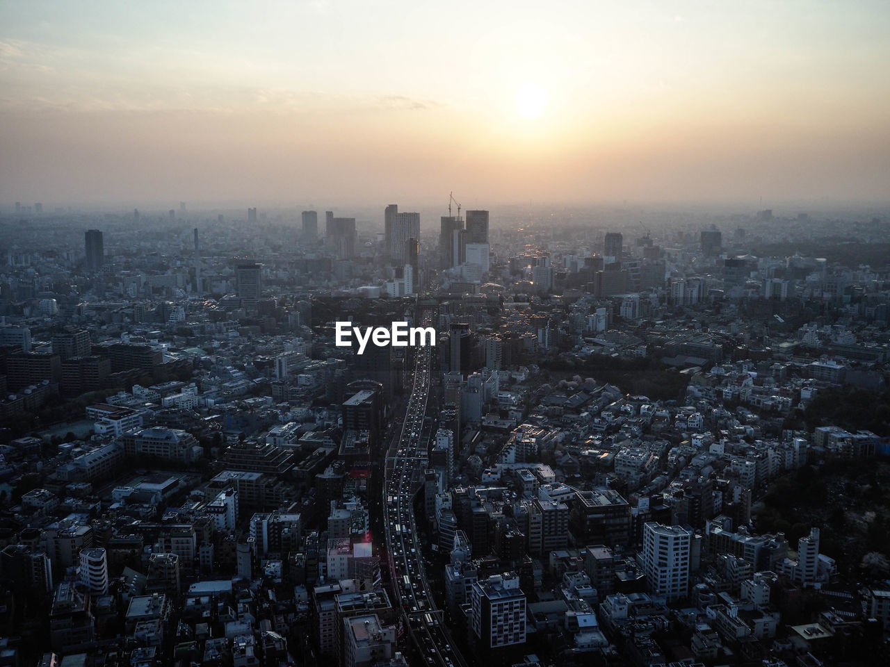 Aerial view of city buildings against sky during sunset