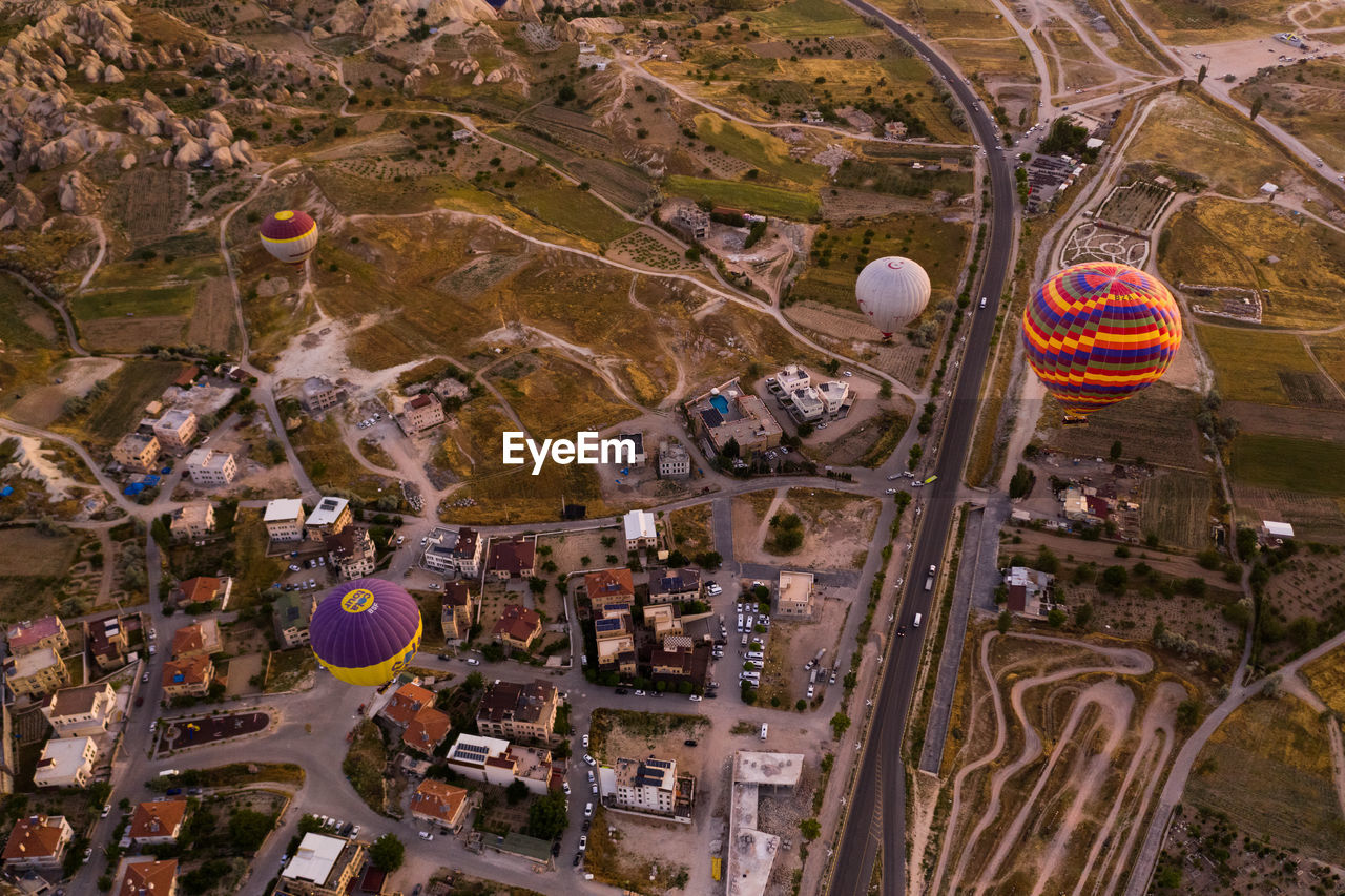 HIGH ANGLE VIEW OF HOT AIR BALLOONS FLYING IN CITY