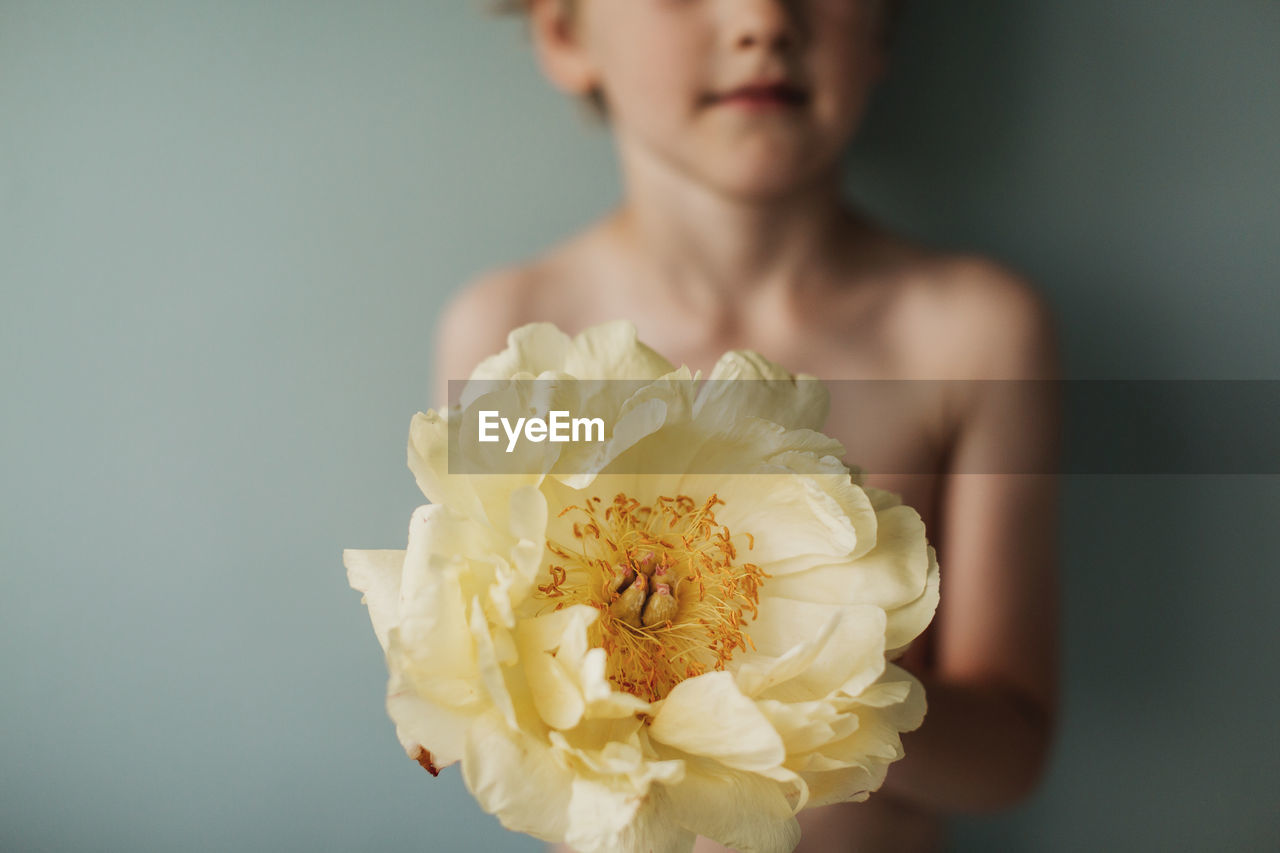 Boy holding yellow flower