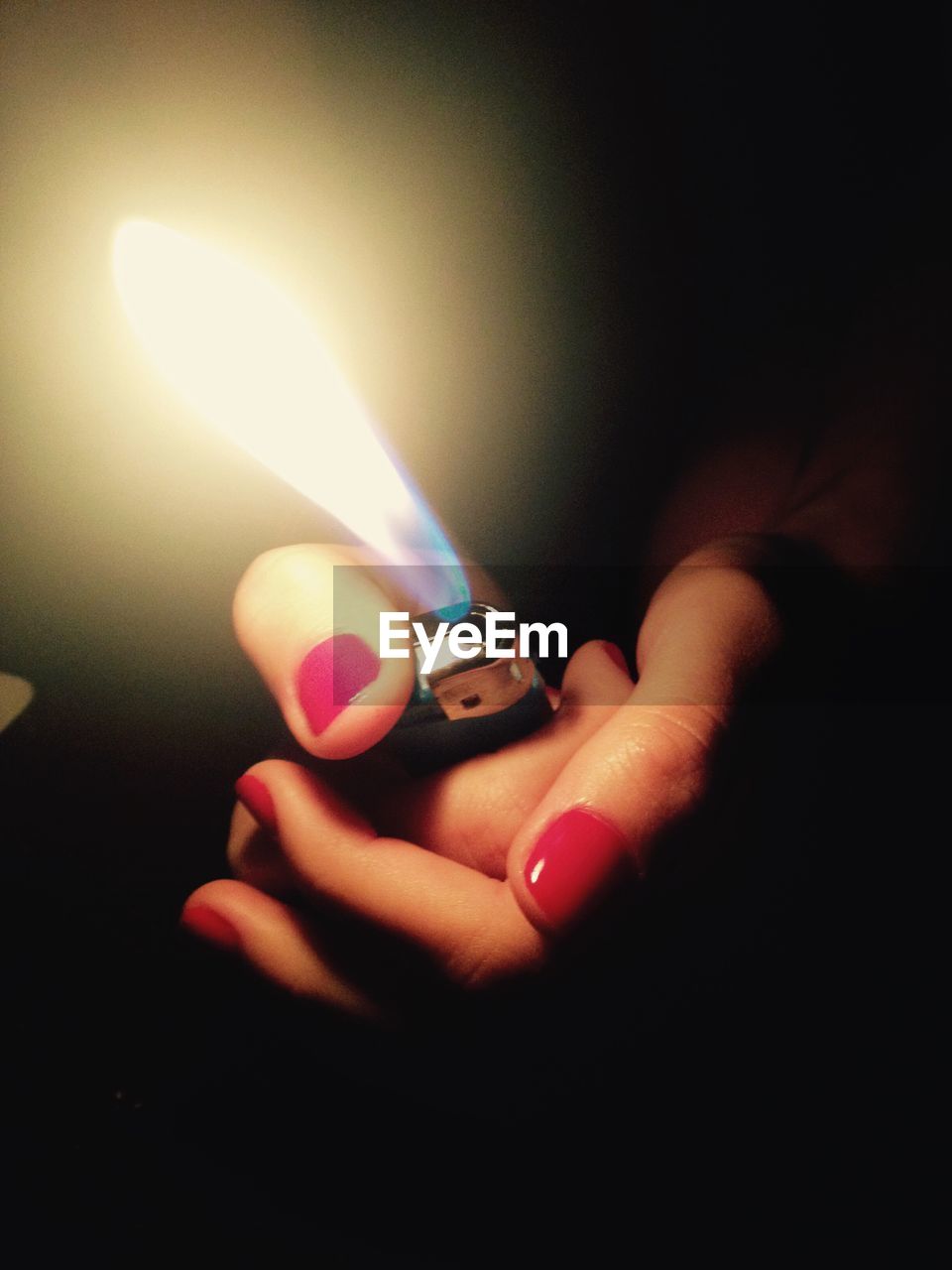 CLOSE-UP OF WOMAN HAND ON ILLUMINATED CANDLES