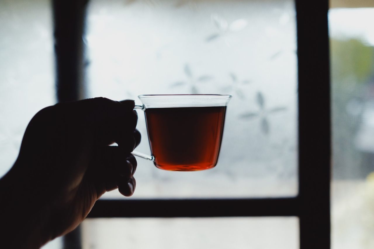 CLOSE-UP OF HAND HOLDING GLASS OF WINDOW