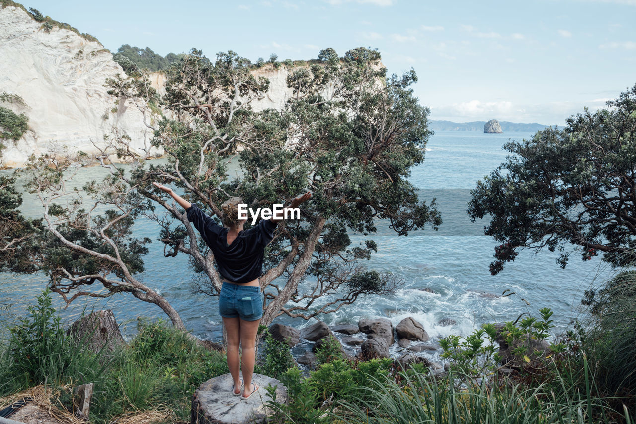 Full length of woman standing on mountain against sky