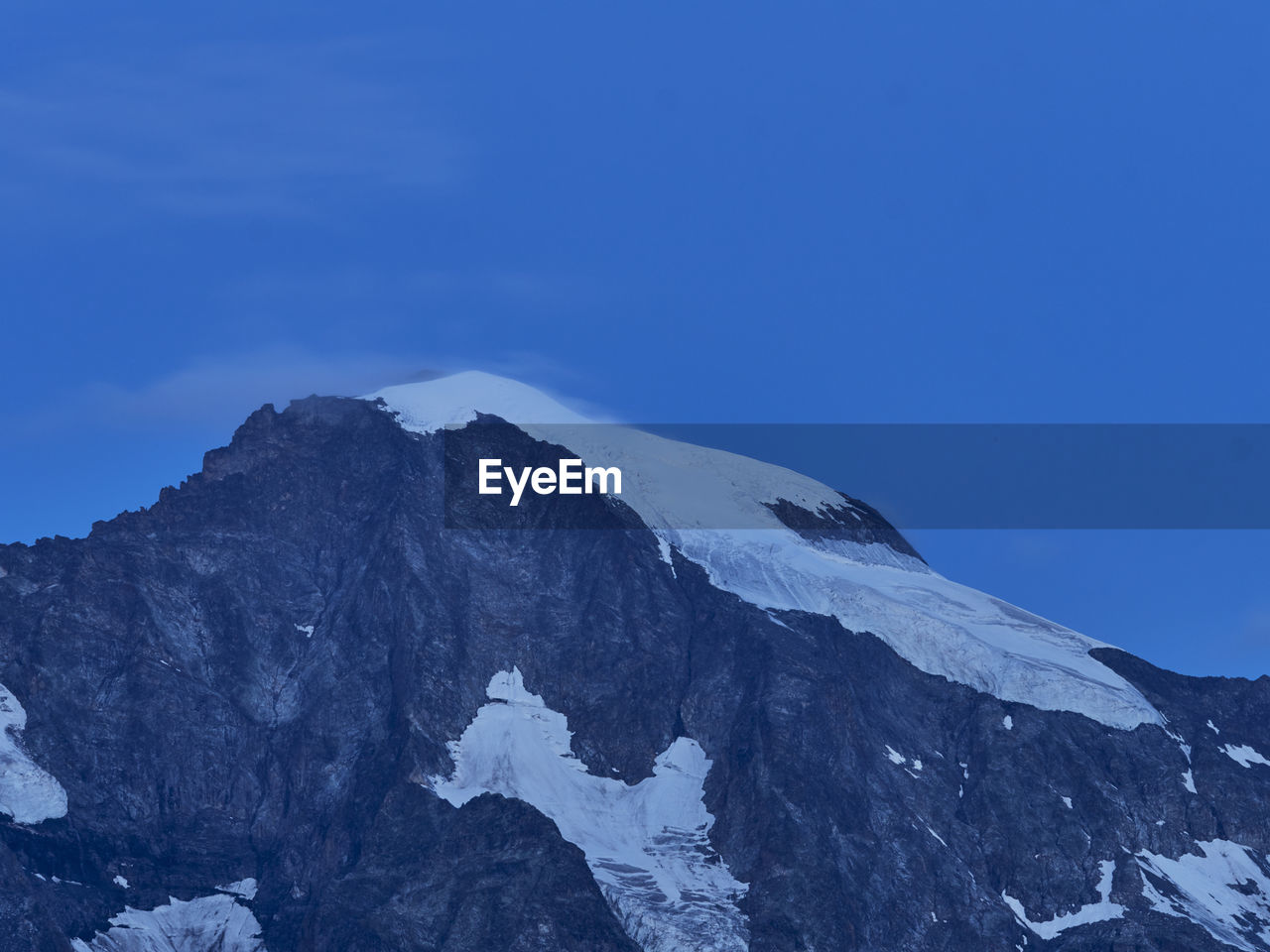 Scenic view of snowcapped mountains against clear blue sky