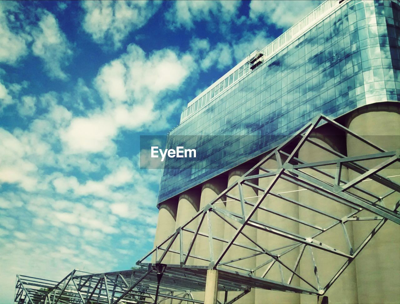 LOW ANGLE VIEW OF MODERN BUILDINGS AGAINST CLOUDY SKY