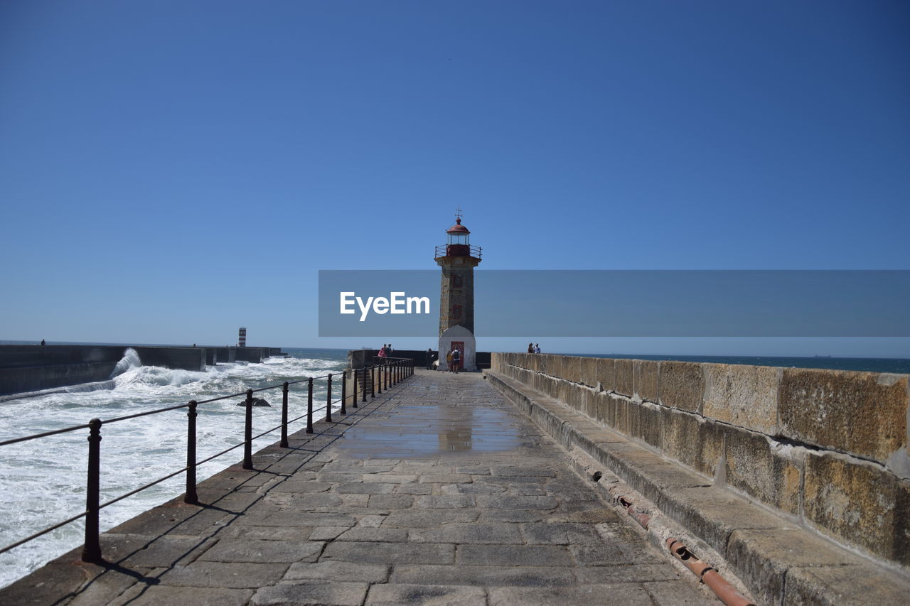 WALKWAY BY SEA AGAINST CLEAR SKY