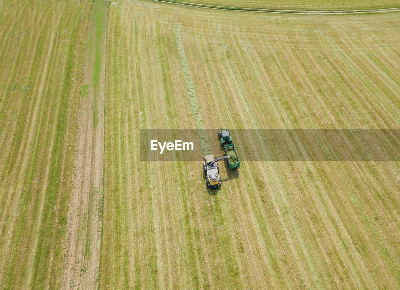 Aerial view of tractor on agricultural landscape during sunny day