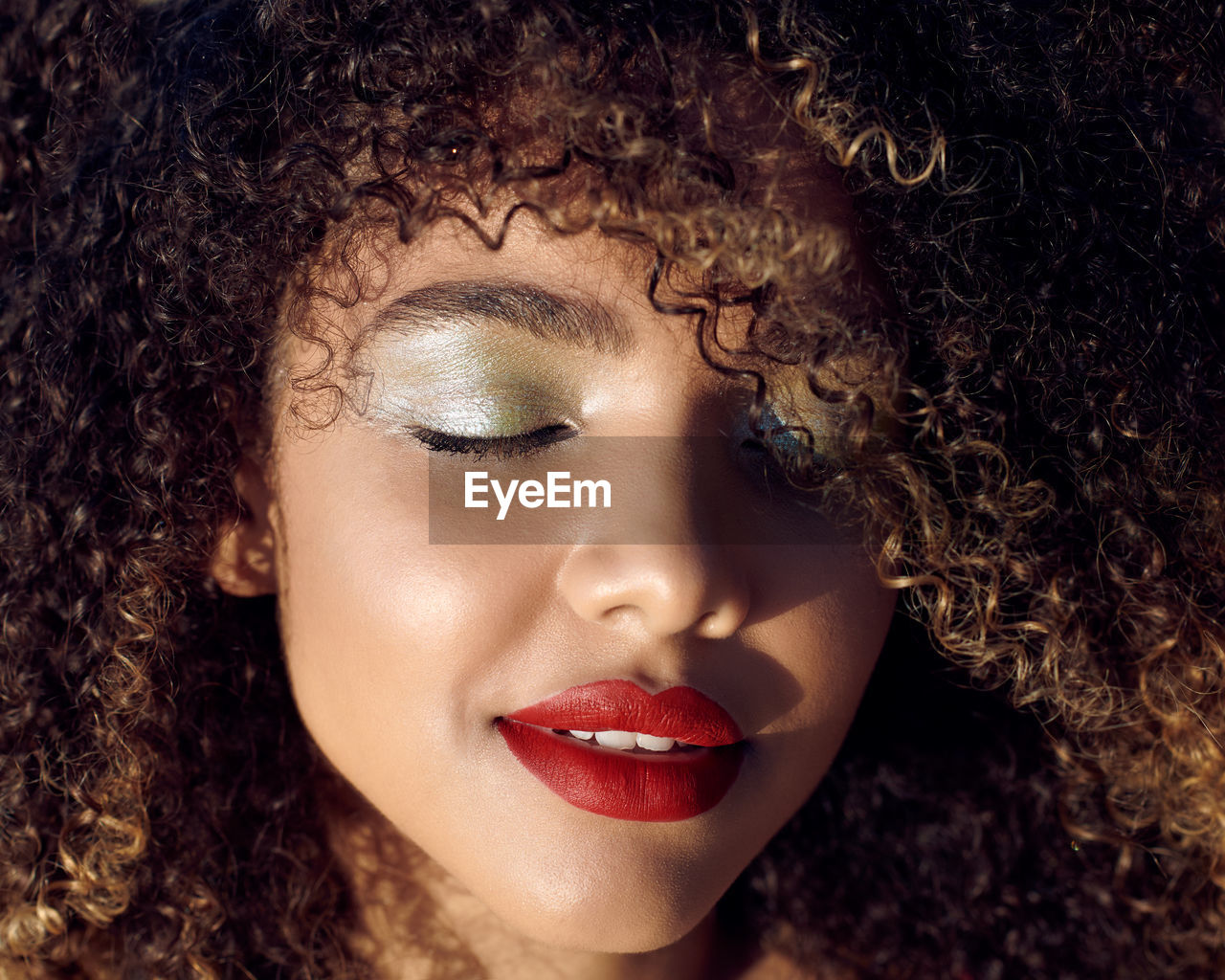 Close-up of young woman with curly hair