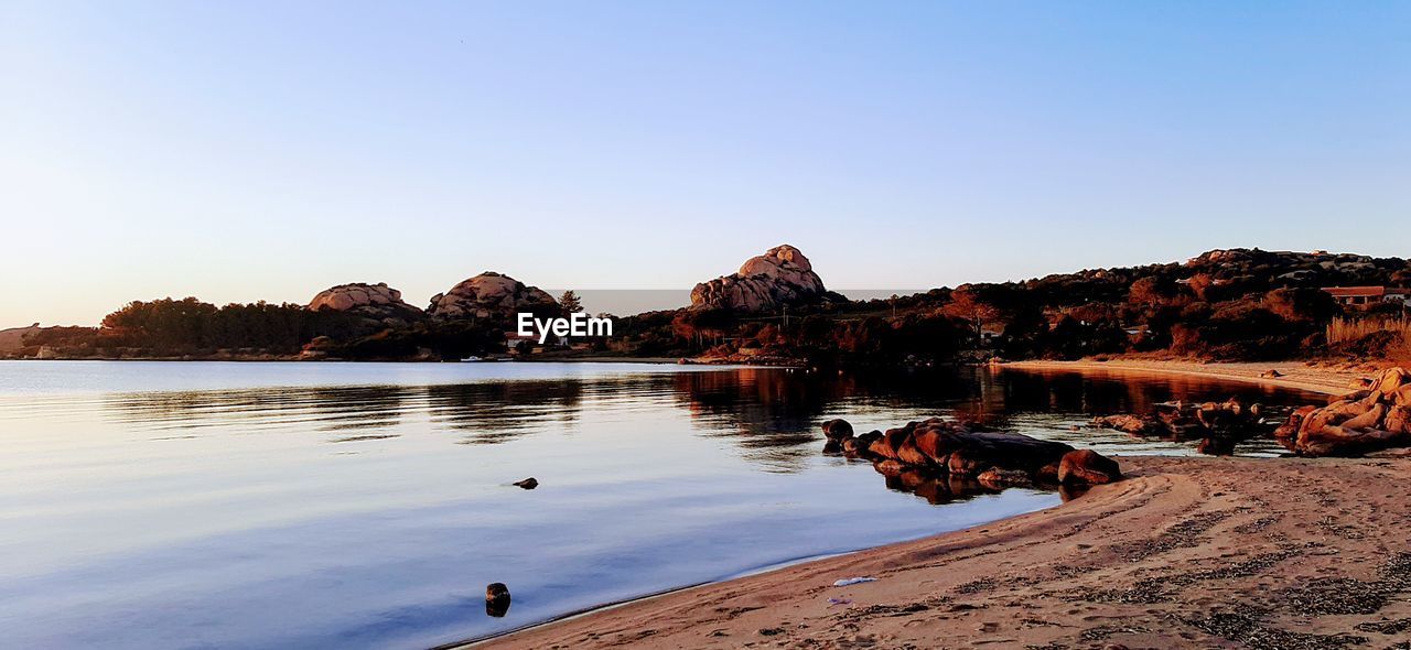 SCENIC VIEW OF LAKE AND ROCKS AGAINST CLEAR SKY