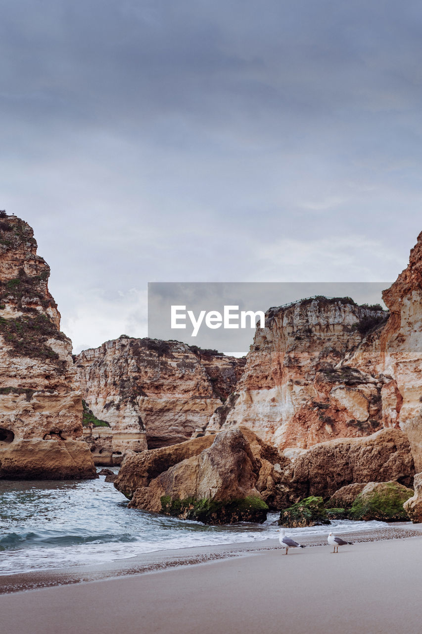 Rock formations by sea against sky