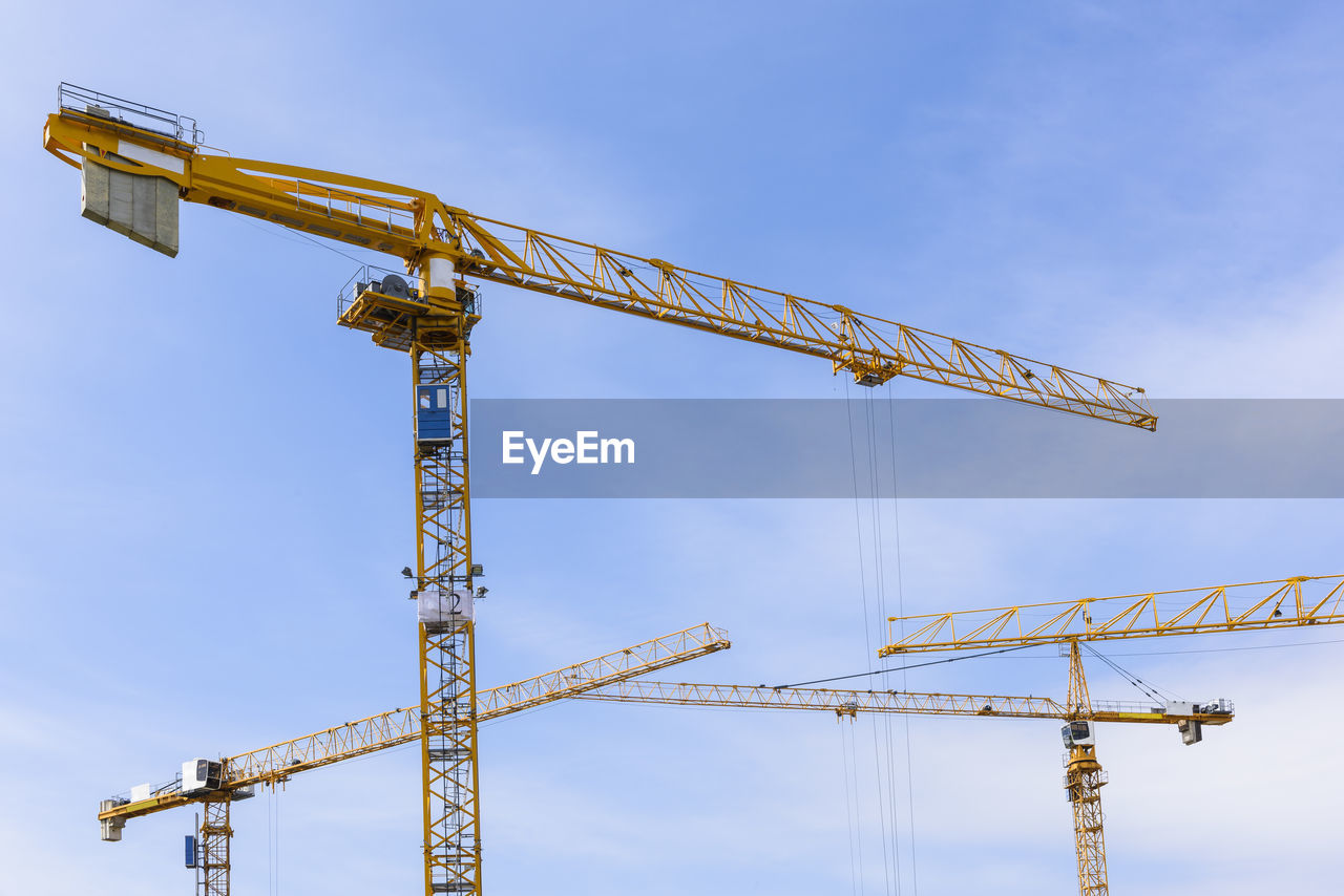 Building cranes against sky