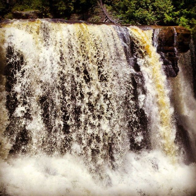 VIEW OF WATERFALL WITH TREES IN BACKGROUND