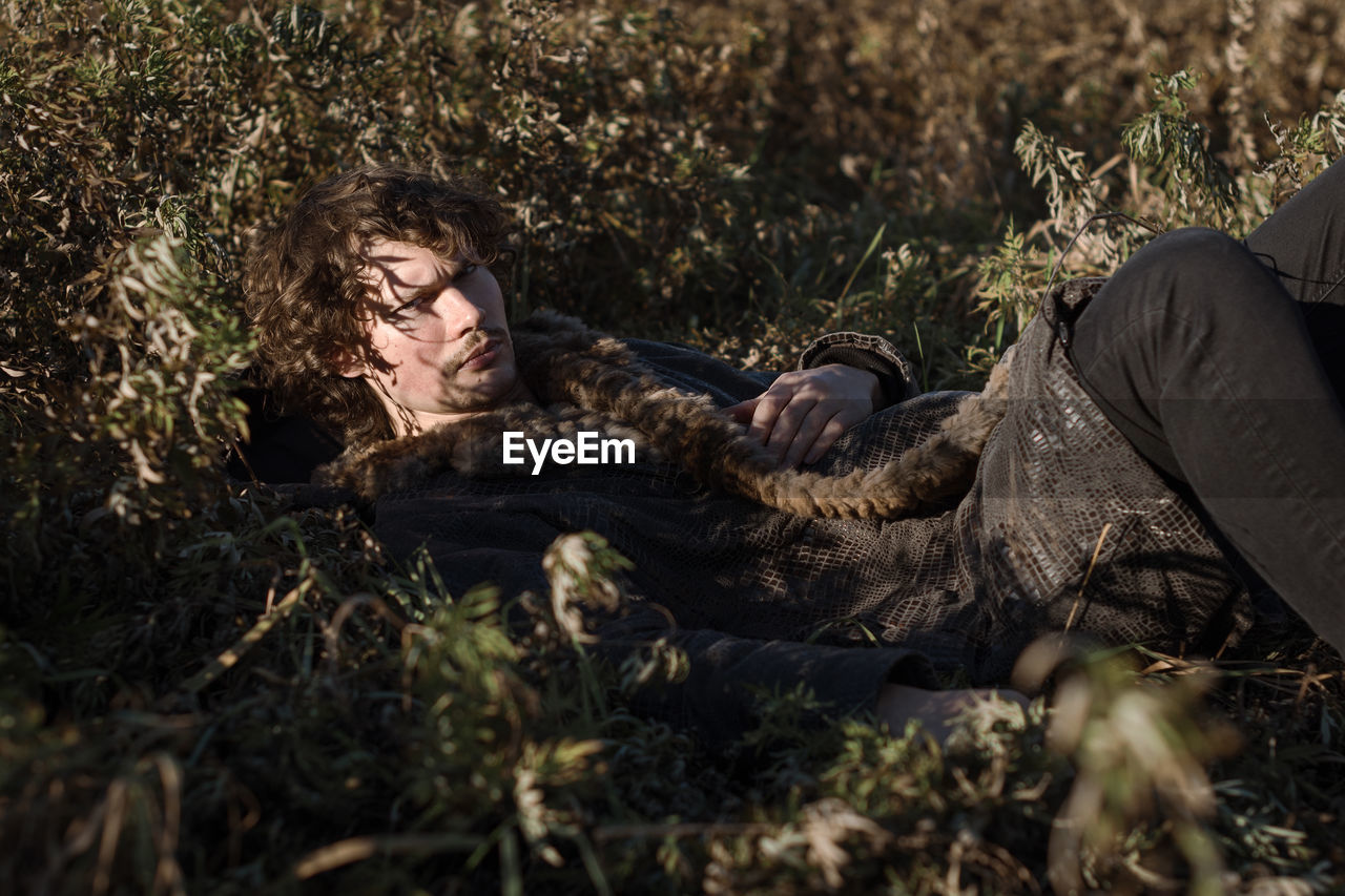 Portrait of man lying down on plants