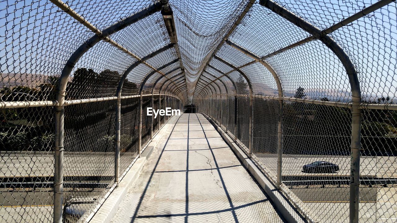 Footbridge in city against sky